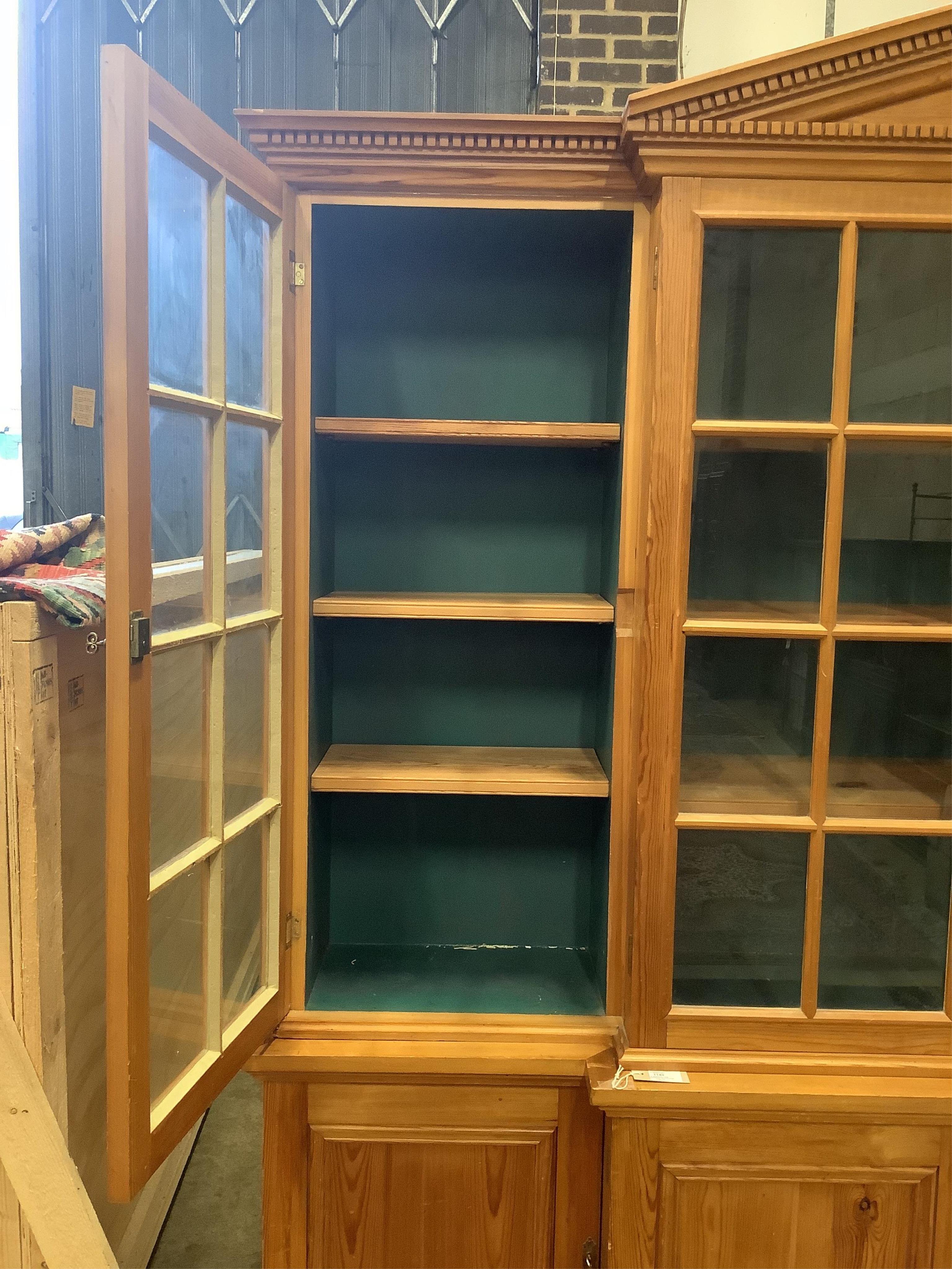 A modern pine breakfront bookcase, width 194cm, depth 44cm, height 207cm. Condition - fair to good